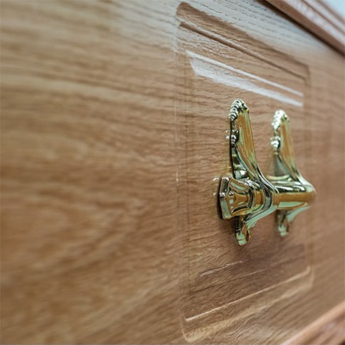 Brass ring handle on the oval embossed panel side of The Dalbury, showing the high gloss oak finish